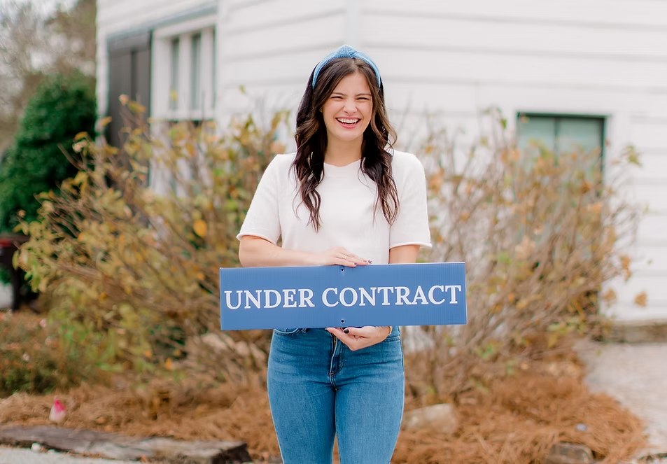 Maddie holding an Under Contract sign